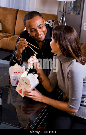 Multi-etnico giovane mangiare Chinese take-out nei moderni loft Foto Stock