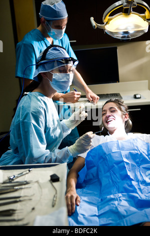 Ritratto di dentista e gli assistenti lavorano su paziente Foto Stock