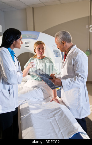 I radiologi e paziente guardando i risultati di analisi CAT Foto Stock