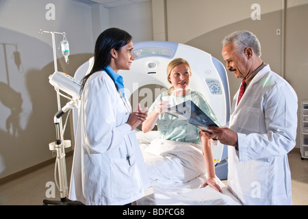 I radiologi e paziente guardando i risultati di analisi CAT Foto Stock