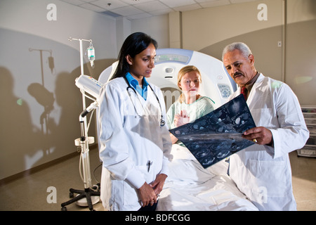 I radiologi e paziente guardando i risultati di analisi CAT Foto Stock