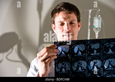 Medico rivedendo i risultati dei test da CAT scan Foto Stock