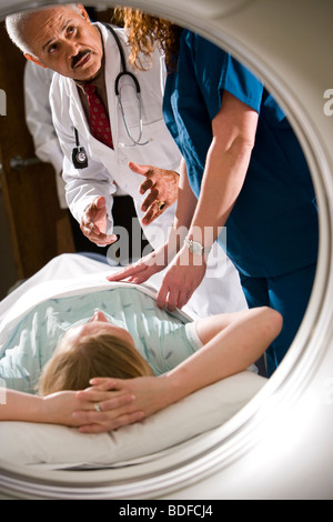 I lavoratori del settore sanitario preparazione paziente per CAT scan Foto Stock