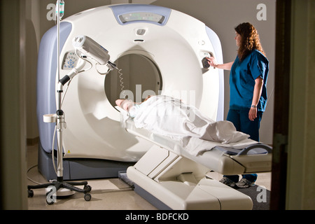 Lavoratore del settore sanitario preparazione paziente per CAT scan Foto Stock