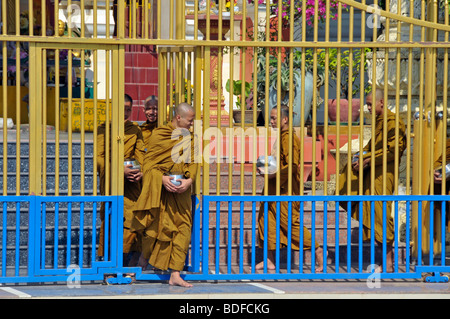 I monaci di lasciare il loro monastero per andare chiedendo l elemosina, Binhabad con accattonaggio o alms ciotola, Phnom Penh, Cambogia, Asia Foto Stock