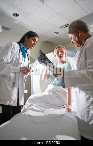 I medici rivedendo CT i risultati di scansione con paziente Foto Stock