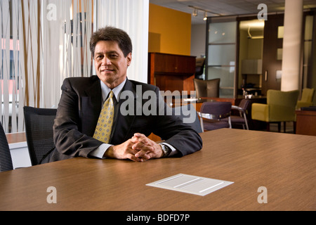 Ritratto di maturo imprenditore ispanica seduto nel posto di lavoro Foto Stock