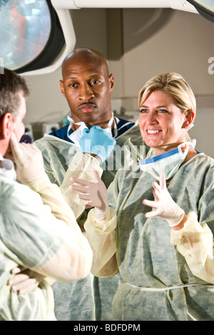 I chirurghi a conversare in sala operatoria dopo la procedura medica Foto Stock