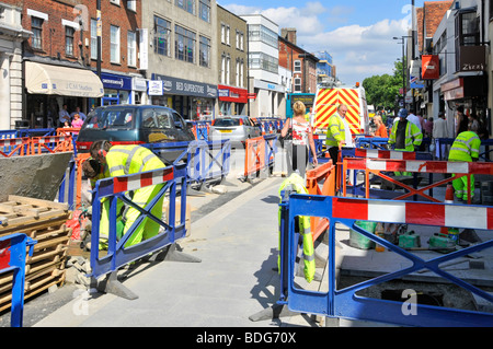 Brentwood shopping alta strada lavori operai in giacche ad alta visibilità miglioramento strada e marciapiede disturbare il traffico e pedoni Essex Inghilterra Foto Stock