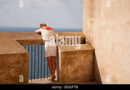 Donna che guarda sulla parete in Bonifacio Corsica Francia Foto Stock