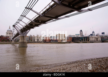 London Millenium Bridge dal Tamigi foreshore in acque basse Foto Stock