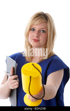 I giovani di 20 anni donna bionda che indossa un tabard blu di una carità lavoratore tenendo fuori una carità cassetta di raccolta Foto Stock