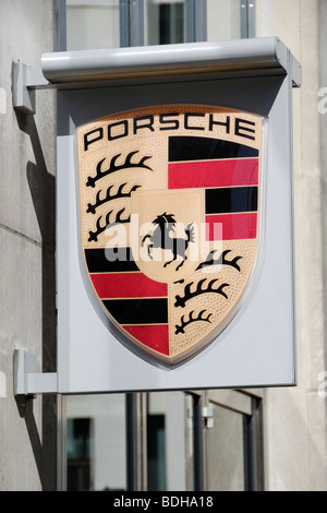 Porsche distintivo logo sul cartello fuori showroom in Mayfair, Londra Foto Stock