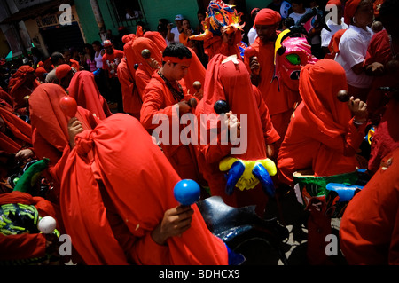 Gli uomini vestiti di rosso costumi di danza con le maracas per celebrare una festa Foto Stock