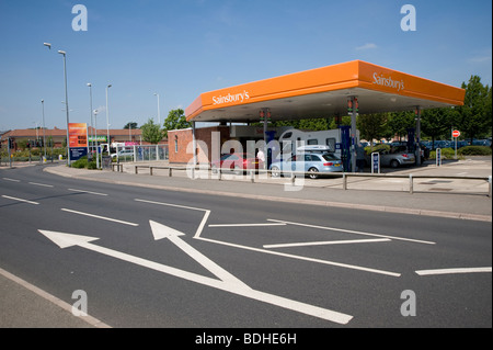 Auto e un motorhome di rifornimento con carburante a un sainsburys stazione di benzina in Inghilterra. Foto Stock