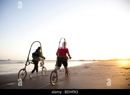 Una nuova forma di bicicletta è testato sulla spiaggia al tramonto. Foto Stock