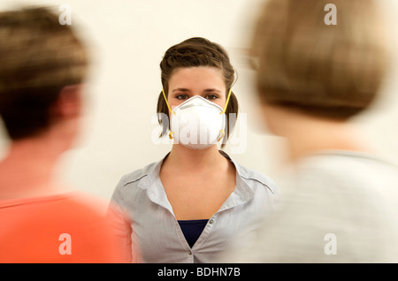 Donna che indossa una maschera di coronavirus che protegge contro l'influenza e la trasmissione del virus Foto Stock