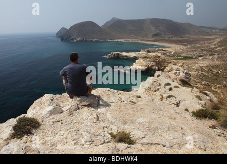 Walker seduti sulle scogliere al di sopra del Castillo de San Ramon guardando il mare di Cabo De Gata Nija Naturel Park Spagna Foto Stock