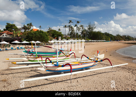 Indonesia, Bali, Sanur, verniciato colorato outrigger barche di pescatori sulla spiaggia Foto Stock