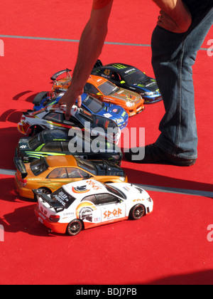 Fila di Toy Cars Racing sul tappeto rosso Foto Stock