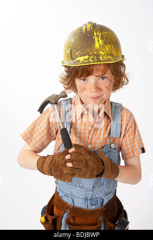 Little Boy vestito come operaio edile tenendo un martello Foto Stock