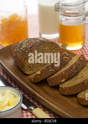Grano intero pane con il miele, latte, marmellate e burro Foto Stock