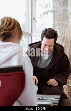 Matura in accappatoi di giocare a Backgammon Foto Stock