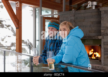 L uomo e la donna in piedi sul balcone Chalet, Whistler, British Columbia, Canada Foto Stock