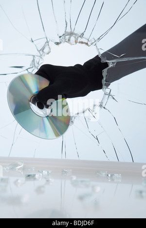 Mano a rubare CD attraverso il vetro rotto Foto Stock