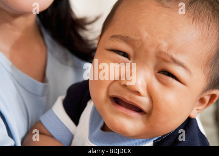 Close-up di pianto, baby boy in madre di braccia Foto Stock