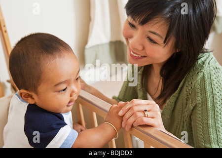 Madre guardando il Bimbo nel presepe Foto Stock