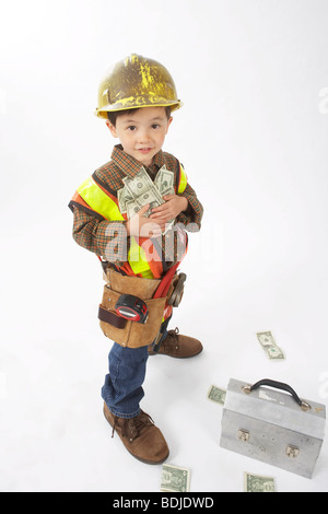 Ragazzo vestito come operaio edile azienda denaro Foto Stock