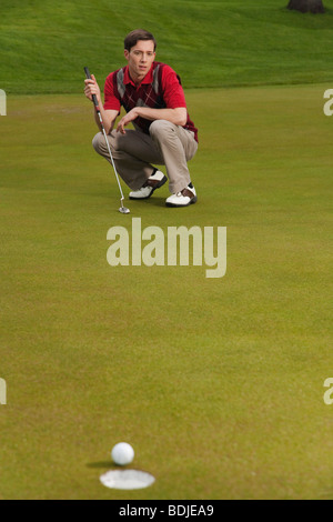 L'uomo guarda il Golf Putt Foto Stock