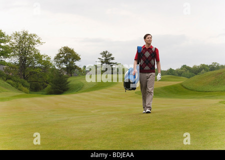 Uomo che cammina sul campo da Golf Foto Stock