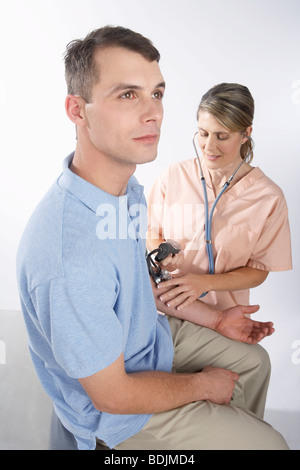 Test di infermiere dell'uomo della pressione del sangue Foto Stock
