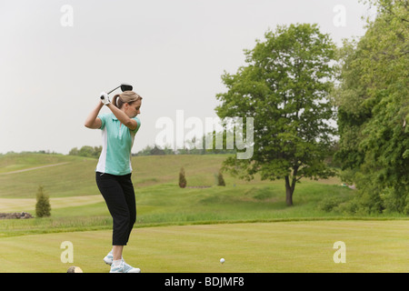 Donna giocando a golf Foto Stock