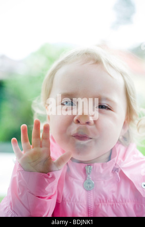 Bambina premendo il suo viso contro la finestra Foto Stock