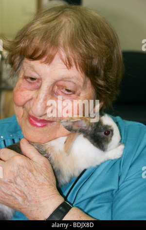 Israele, Rehovot, vecchiaia centro per la cura giornaliera del titolare di pensione o di rendita di prendersi cura di un animale da compagnia il coniglio come parte della loro attività quotidiana Foto Stock