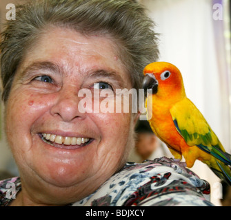 Israele, Rehovot, vecchiaia centro per la cura giornaliera del titolare di pensione o di rendita di prendersi cura di un animale domestico parrot come parte della loro attività quotidiana Foto Stock