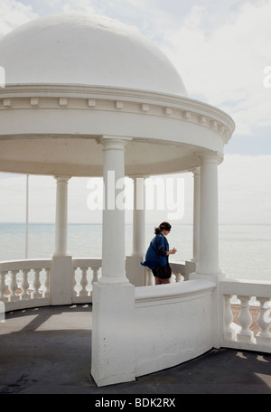 Ragazza che guarda al mare sotto Bexhill dome pavilion Foto Stock