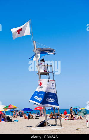 Spagna , Valencia , spiaggia in scena con la Croce Rossa o Cruz Roja lifeguard & la gente a prendere il sole e ombrelloni su Playa de la Malvarrosa Foto Stock