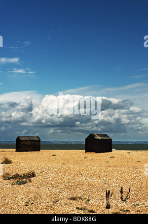 Fishermens capanne in legno sulla spiaggia di ciottoli a Dungeness nel Kent. Foto Stock