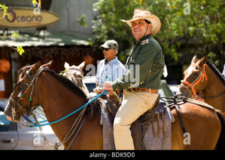 Un cowboy ottiene sul suo cavallo in Guanacaste ad una sfilata di cavalli o Tope a Tamarindo Costa Rica come parte di una celebrazione tradizionale Foto Stock