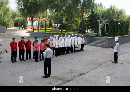 DATONG, nella provincia di Shanxi, Cina - Agosto 2007: Jing Yuan Hotel staff roll call nelle prime ore del mattino Foto Stock