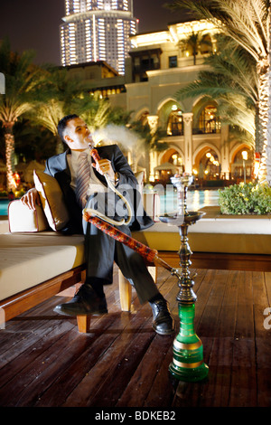 Dubai Emirati Arabi Uniti: Il Palace Hotel nel centro cittadino di Dubai, gli uomini sono il fumo di un tubo di acqua. Foto Stock