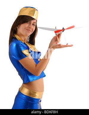 Modello femminile in convenzionati tuta blu dimostra aeroplano giocattolo, isolato su bianco Foto Stock