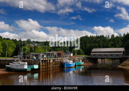 Ponte coperto e molo con barche a bassa marea in St Martins Baia di Fundy New Brunswick canada Foto Stock