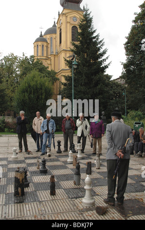 Un gruppo di uomini giocano su una vita dimensioni scheda di scacchi in una piazza della città nella città di Sarajevo, Bosnia ed Erzegovina. Foto Stock