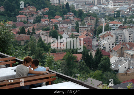 Un paio di condividere un momento romantico in un ristorante e sulla terrazza che si affaccia sulla città di Sarajevo in Bosnia ed Erzegovina. Foto Stock