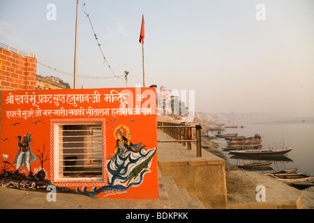 Un dipinto luminosamente tempio sorge sulle rive del Gange (Gange) fiume di Varanasi (India). Foto Stock